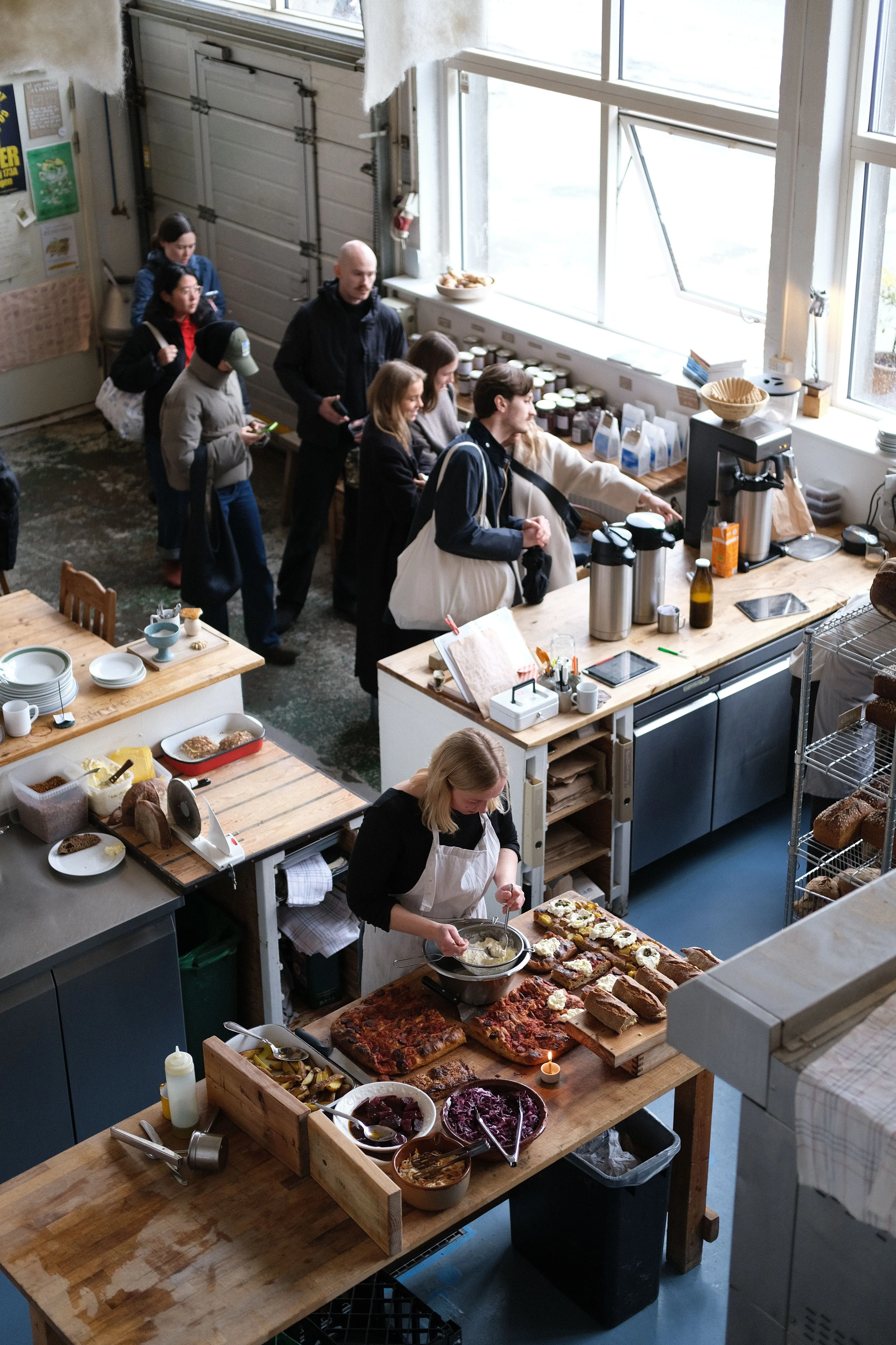 Busy cafe counter with a queue of customers, showing modern queue management solutions.