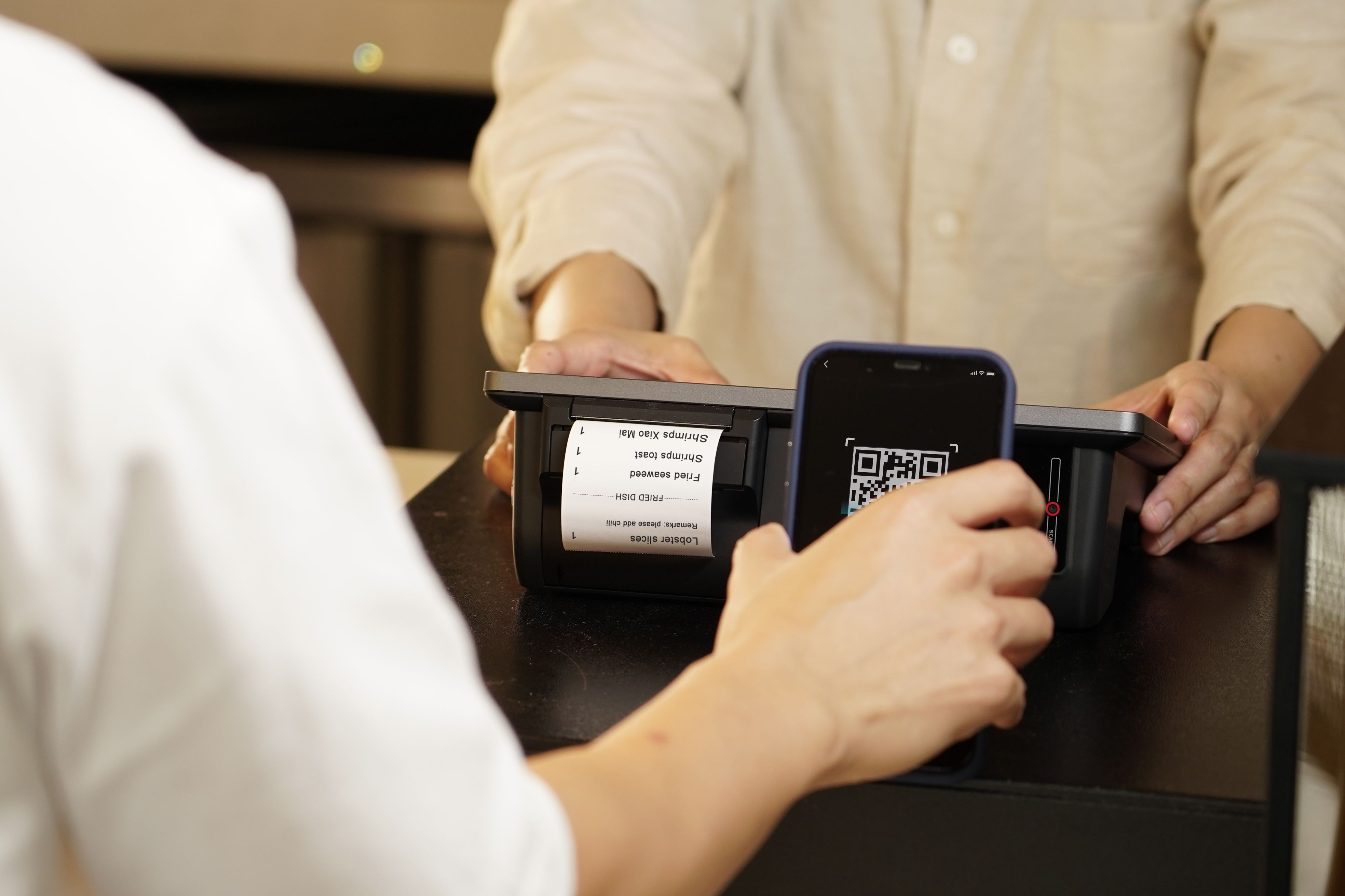 A customer scanning a QR code on a digital device to open the ordering menu.