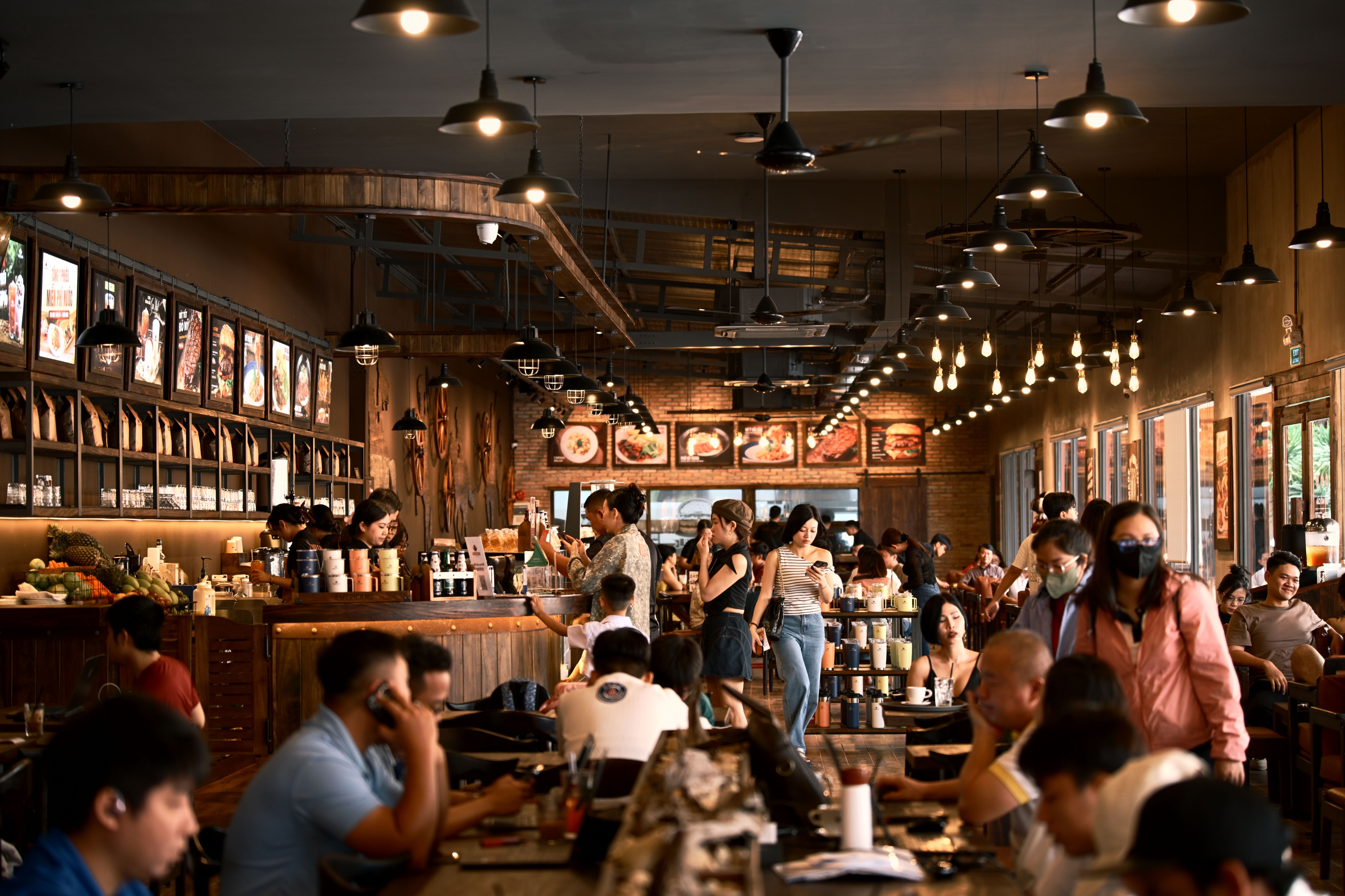 Efficient cafe staff managing a crowded venue with the help of smart hospitality technology.
